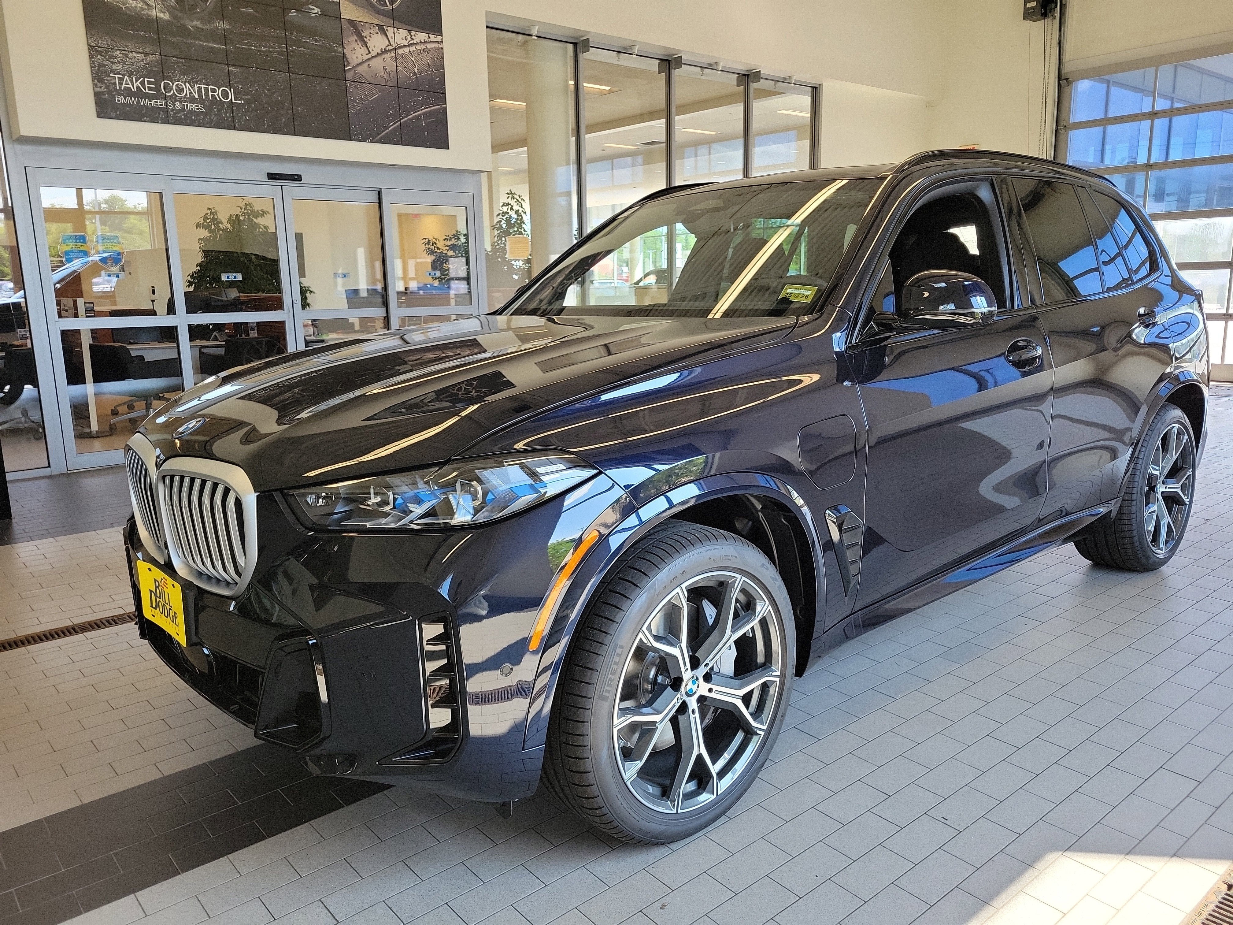 2026 BMW X5 xDrive50e in Carbon Black Metallic — front three-quarter view